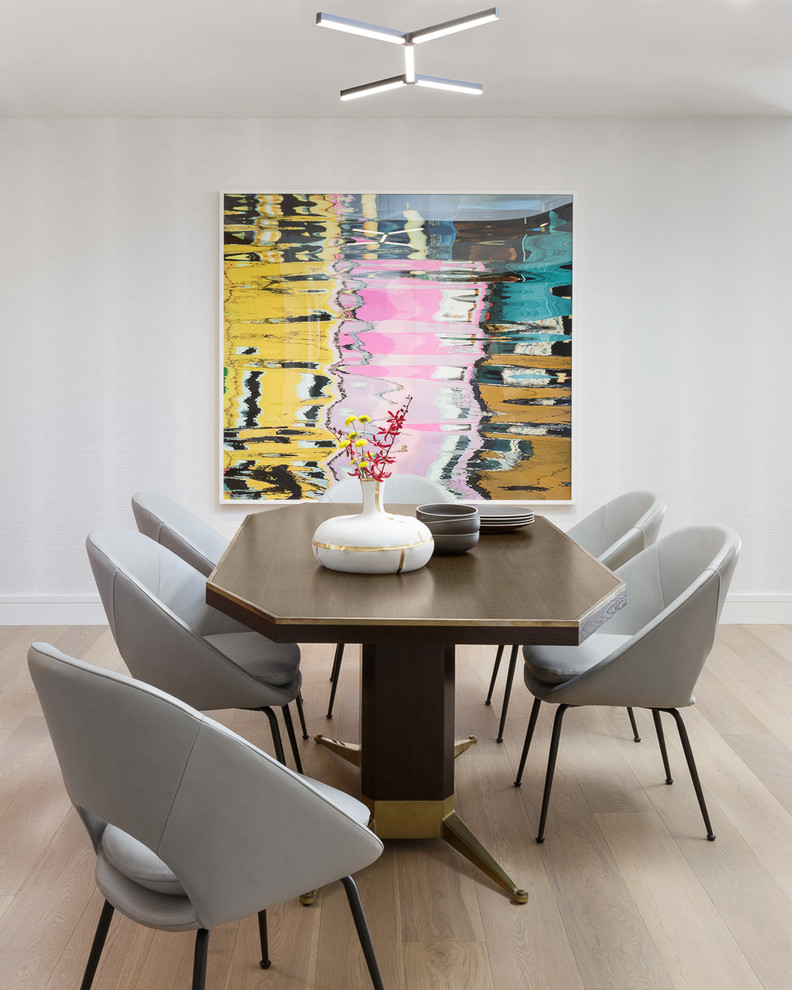 Foto di una sala da pranzo aperta verso il soggiorno minimalista di medie dimensioni con pareti bianche, parquet chiaro e pavimento beige
