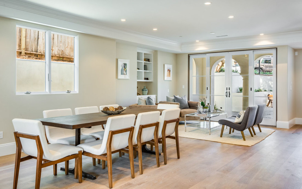 Exemple d'une salle à manger ouverte sur le salon chic avec un mur beige et parquet clair.