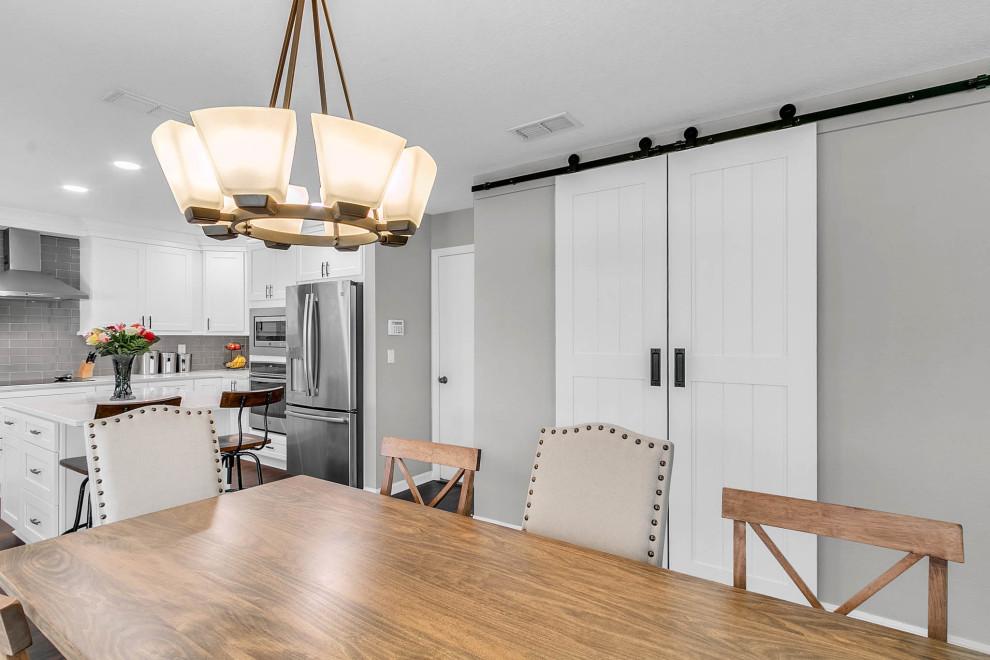 Immagine di una sala da pranzo aperta verso la cucina tradizionale di medie dimensioni con pareti grigie, pavimento in laminato e pavimento marrone