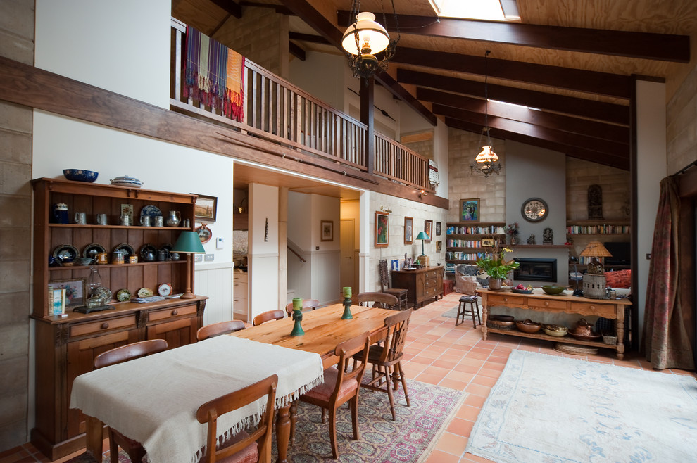 Inspiration pour une salle à manger ouverte sur le salon rustique de taille moyenne avec un mur marron et tomettes au sol.