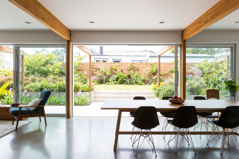Идея дизайна: маленькая кухня-столовая в современном стиле с белыми стенами и бетонным полом для на участке и в саду