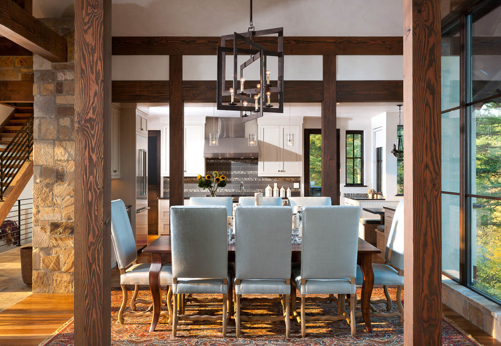 Réalisation d'une salle à manger ouverte sur la cuisine chalet avec un mur beige et un sol en bois brun.