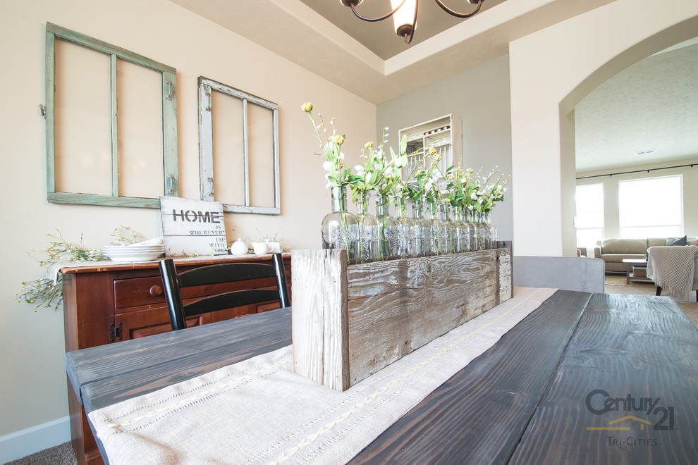 На фото: гостиная-столовая в стиле рустика с бежевыми стенами и ковровым покрытием с