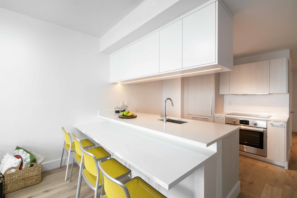 Idée de décoration pour une petite salle à manger ouverte sur la cuisine marine avec un mur blanc, parquet clair et un sol beige.