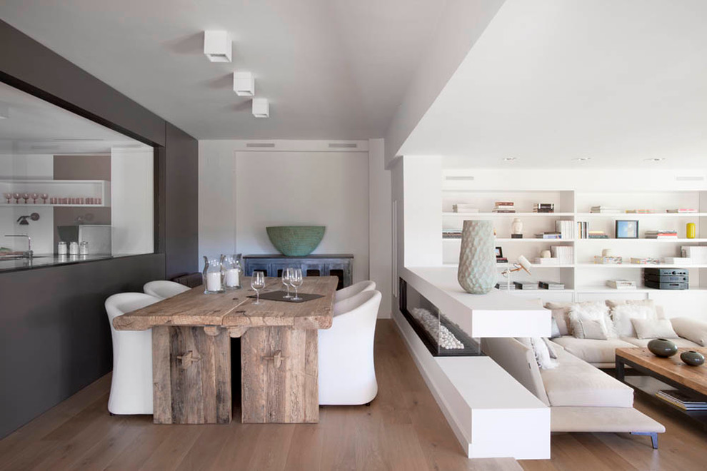 Modernes Esszimmer mit weißer Wandfarbe und braunem Holzboden in Barcelona