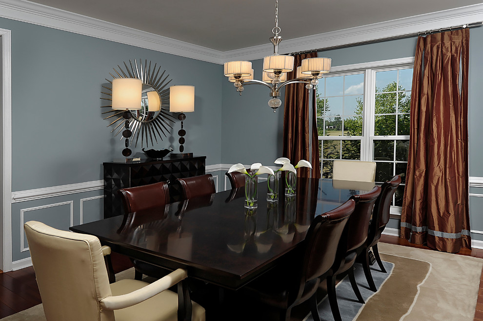На фото: большая отдельная столовая в классическом стиле с синими стенами и темным паркетным полом без камина