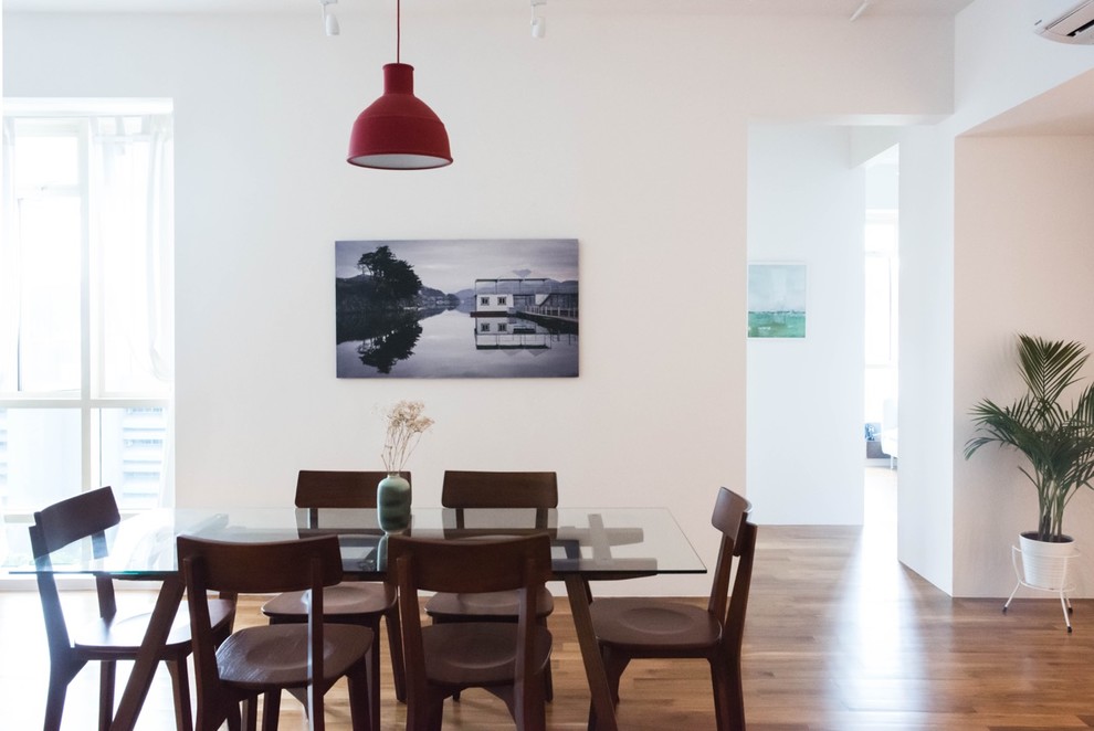 Cette photo montre une salle à manger moderne avec un mur blanc, un sol en bois brun et un sol marron.