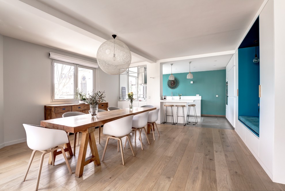 Danish medium tone wood floor and brown floor kitchen/dining room combo photo in Tel Aviv with white walls