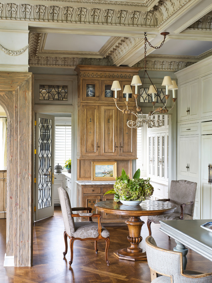 Cette image montre une petite salle à manger ouverte sur la cuisine victorienne avec un sol en bois brun et aucune cheminée.