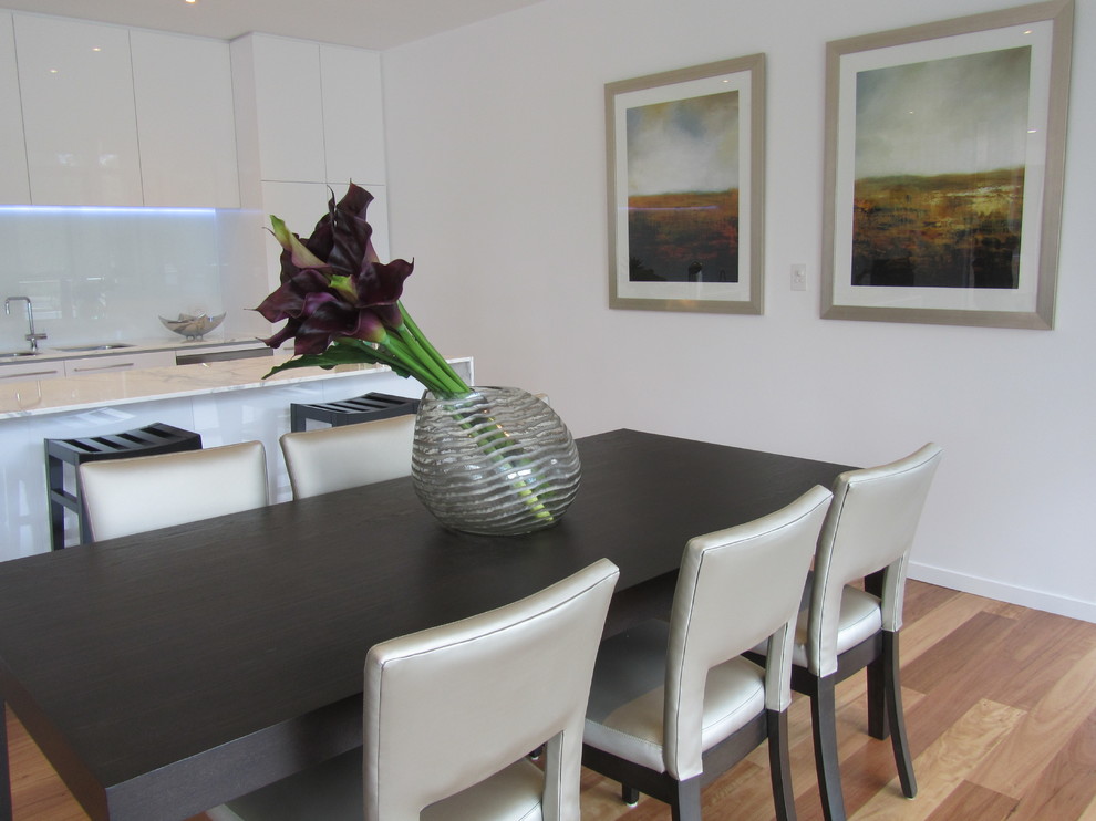 Photo of a medium sized contemporary open plan dining room in Adelaide with white walls, medium hardwood flooring and no fireplace.