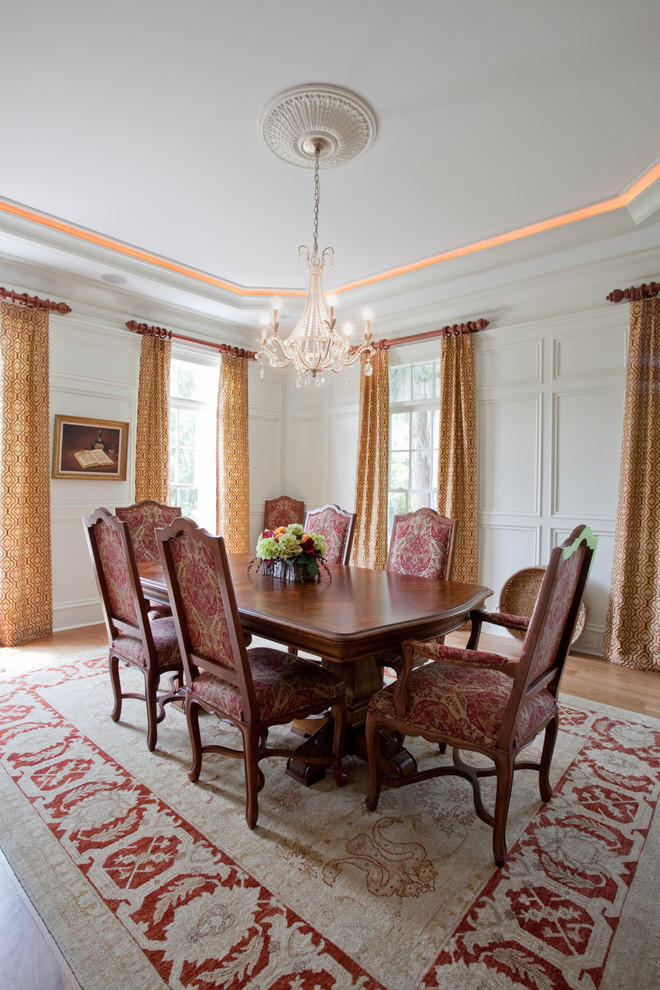 Immagine di una sala da pranzo classica con pareti bianche e pavimento in legno massello medio