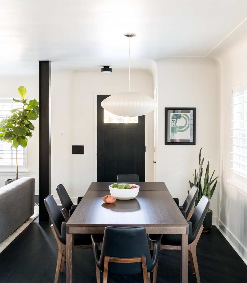 Imagen de comedor minimalista de tamaño medio abierto sin chimenea con paredes blancas y suelo de madera oscura