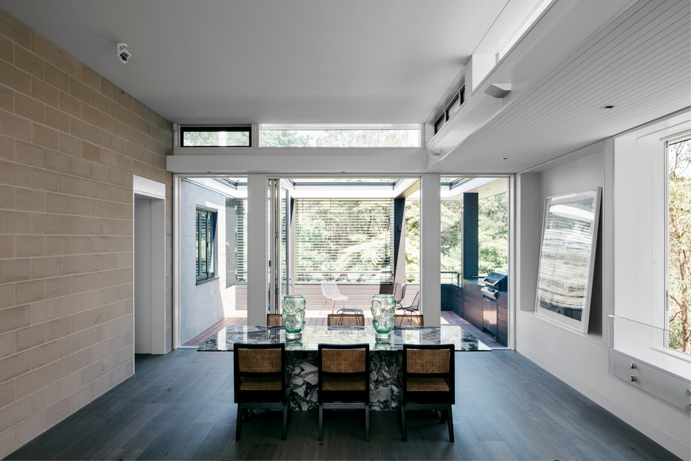 На фото: столовая в современном стиле с белыми стенами, темным паркетным полом и серым полом с