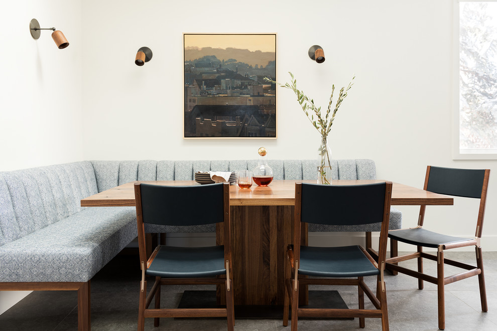 Ispirazione per una sala da pranzo aperta verso la cucina moderna di medie dimensioni con pareti bianche, pavimento in gres porcellanato e pavimento grigio