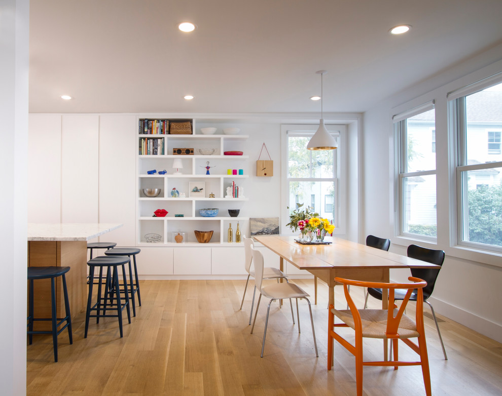 Immagine di una sala da pranzo aperta verso la cucina design con pareti bianche, parquet chiaro e pavimento marrone