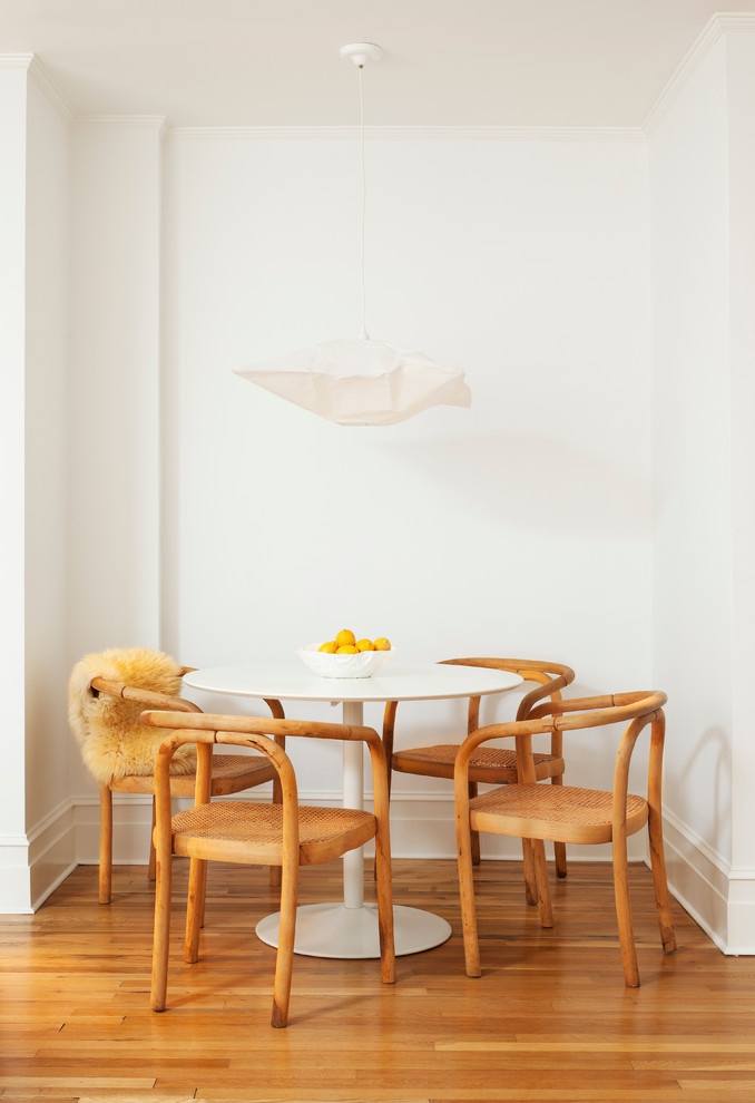 Ejemplo de comedor escandinavo pequeño con paredes blancas y suelo de madera en tonos medios