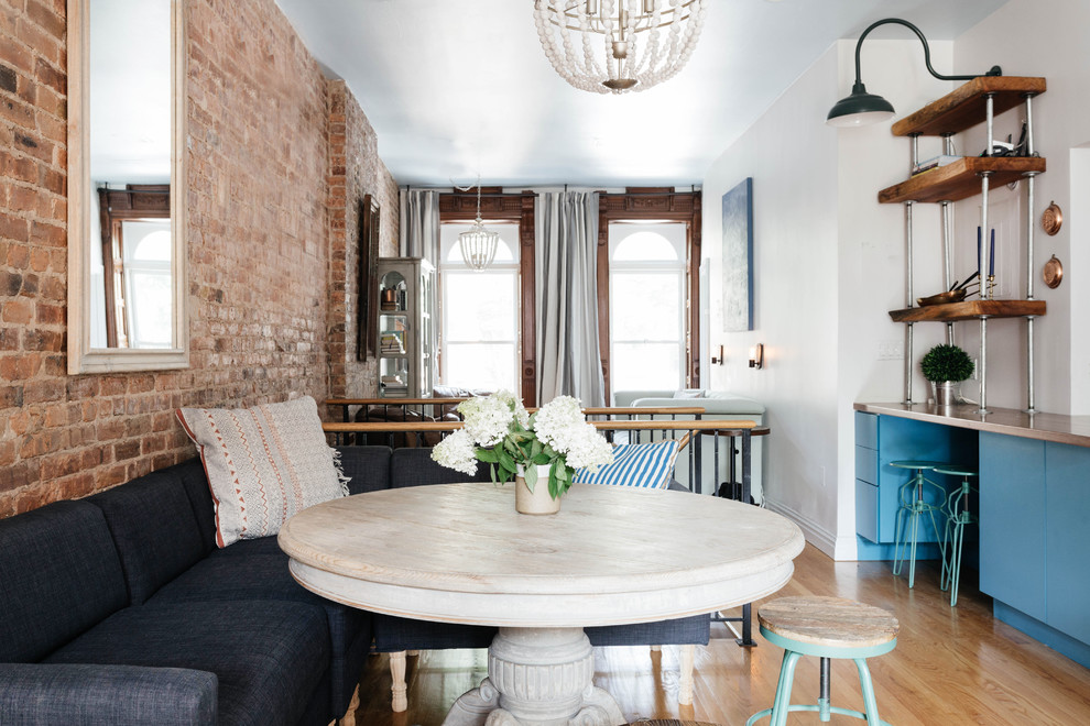 Kleine Landhaus Wohnküche mit weißer Wandfarbe und braunem Holzboden in New York