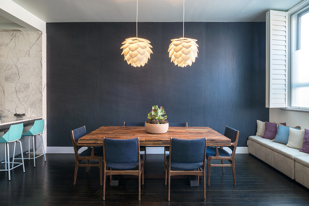 Idee per una sala da pranzo aperta verso la cucina design con pareti nere e pavimento in legno verniciato
