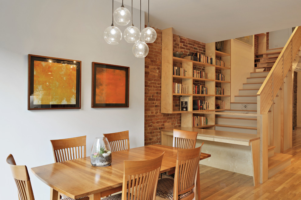Cette image montre une salle à manger bohème avec un mur blanc et un sol en bois brun.