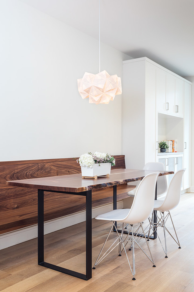 Idée de décoration pour une salle à manger ouverte sur la cuisine design de taille moyenne avec un mur blanc, un sol en bois brun et un sol marron.