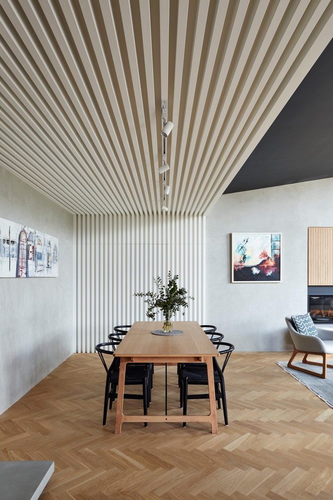 Exemple d'une salle à manger ouverte sur le salon tendance avec un mur gris, parquet clair et un sol beige.