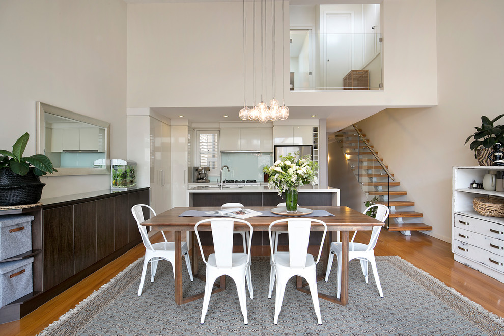 Moderne Wohnküche ohne Kamin mit beiger Wandfarbe und braunem Holzboden in Sydney