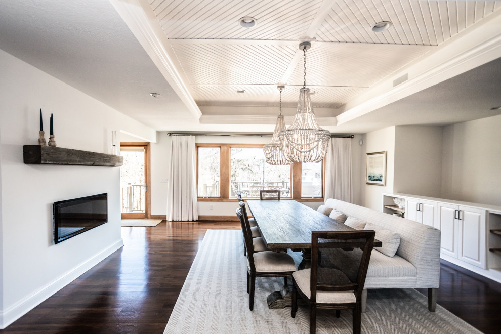 Immagine di una sala da pranzo aperta verso il soggiorno stile marino con pareti bianche e soffitto ribassato