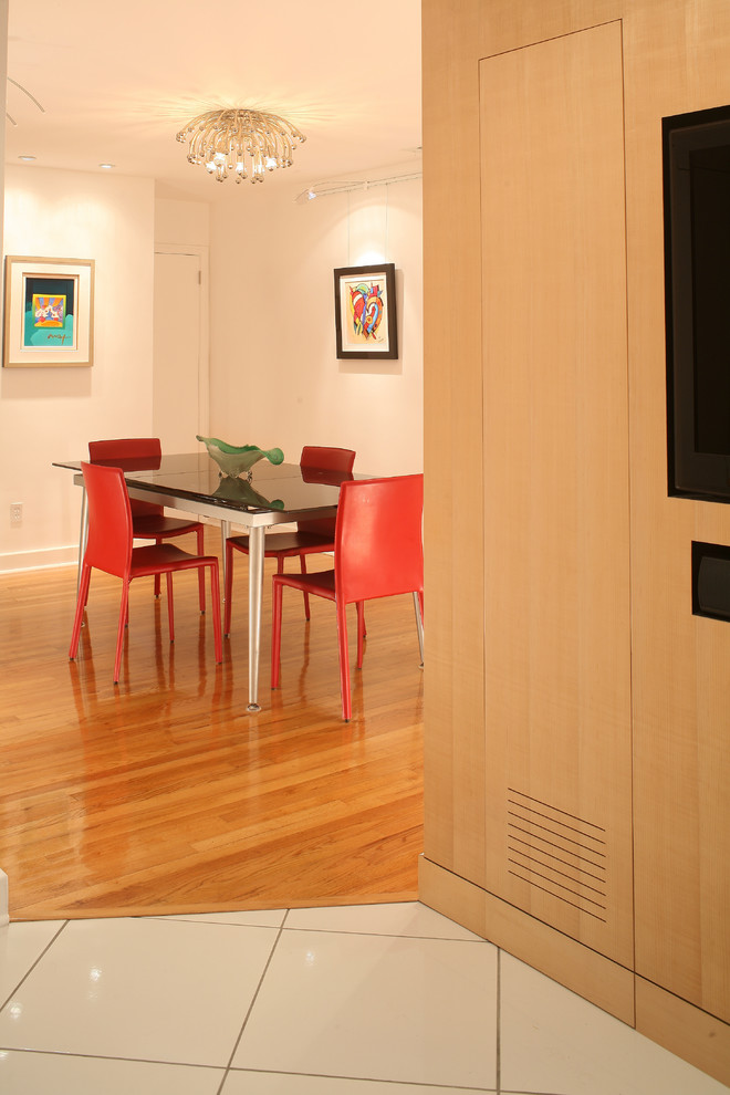 Cette photo montre une petite salle à manger tendance fermée avec un mur blanc et un sol en bois brun.