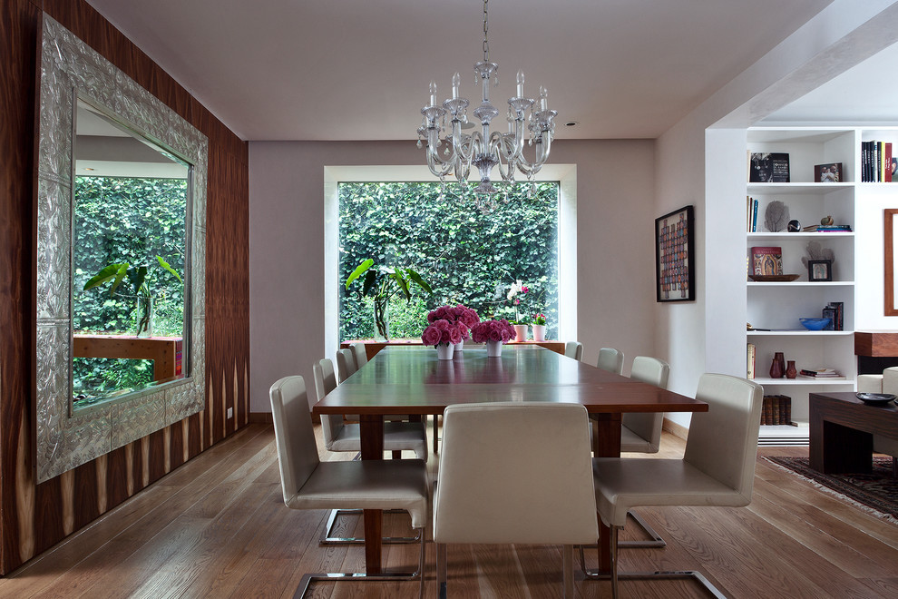 Contemporary dining room in Mexico City with grey walls, dark hardwood flooring and feature lighting.