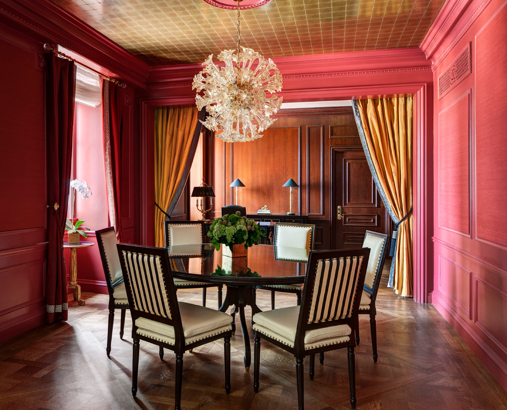 Aménagement d'une salle à manger classique fermée avec un mur rose et un sol en bois brun.