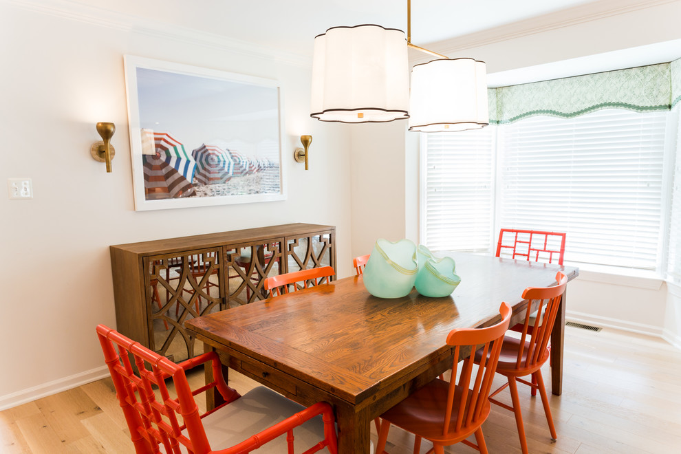 This is an example of a small nautical open plan dining room in DC Metro with white walls, light hardwood flooring and no fireplace.