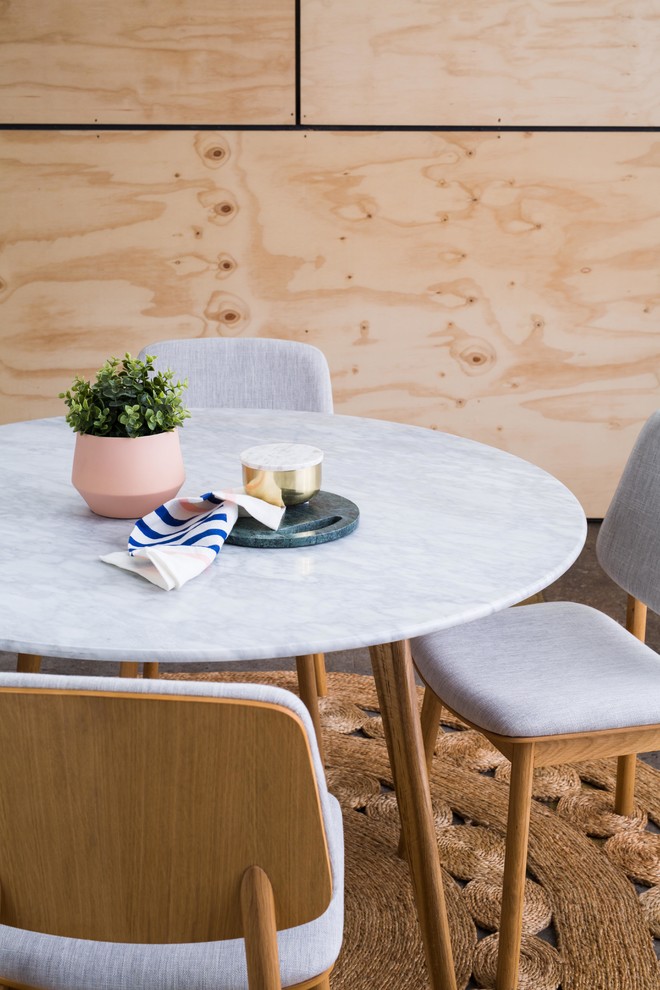 Cette photo montre une salle à manger scandinave de taille moyenne avec un mur beige, sol en béton ciré, aucune cheminée et un sol marron.
