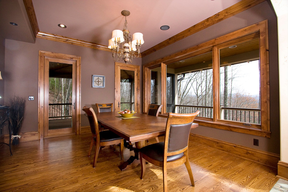 На фото: столовая в классическом стиле с коричневыми стенами и паркетным полом среднего тона с