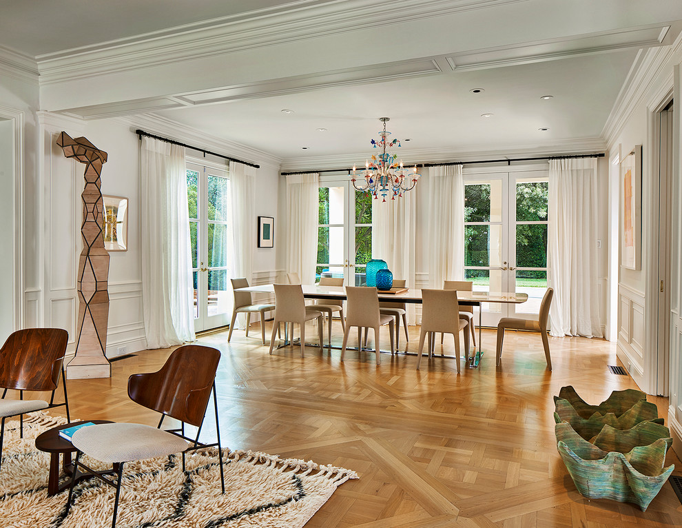 Inspiration pour une grande salle à manger ouverte sur le salon minimaliste avec un mur blanc, un sol en bois brun, une cheminée double-face, un manteau de cheminée en béton et un sol marron.