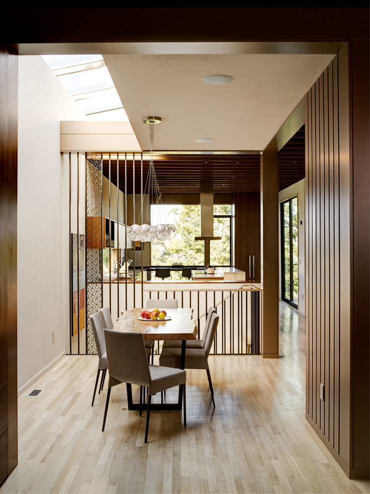Photo of a midcentury dining room in Seattle with white walls, light hardwood flooring and beige floors.