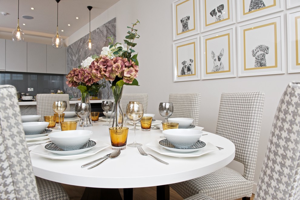 Ispirazione per una sala da pranzo aperta verso la cucina classica con pareti grigie e parquet chiaro