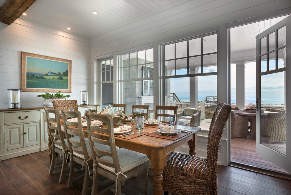 Exemple d'une salle à manger bord de mer de taille moyenne avec un mur blanc, parquet foncé et un sol marron.