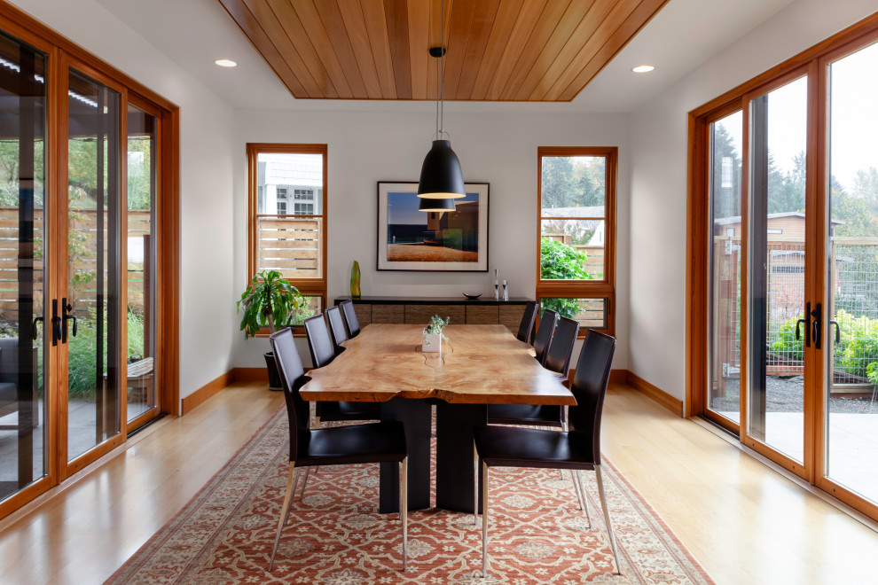 Ispirazione per una grande sala da pranzo minimalista chiusa con pareti bianche, pavimento beige e soffitto in legno