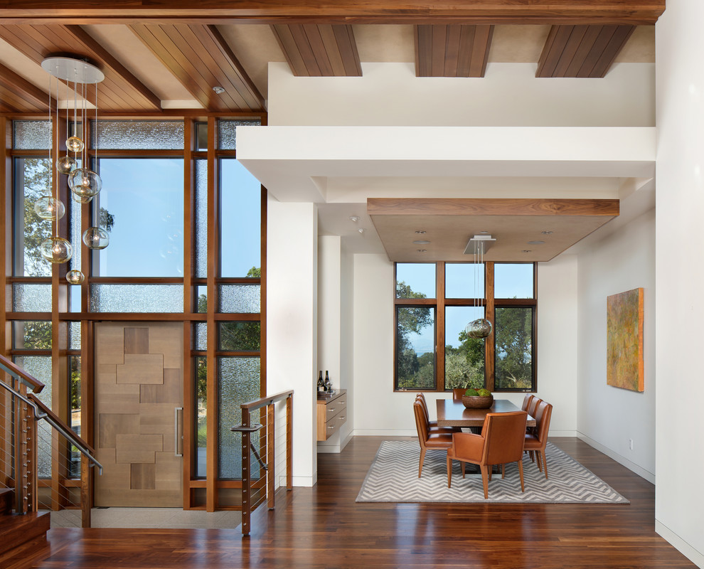 Contemporary open plan dining room in San Francisco with white walls, medium hardwood flooring and brown floors.