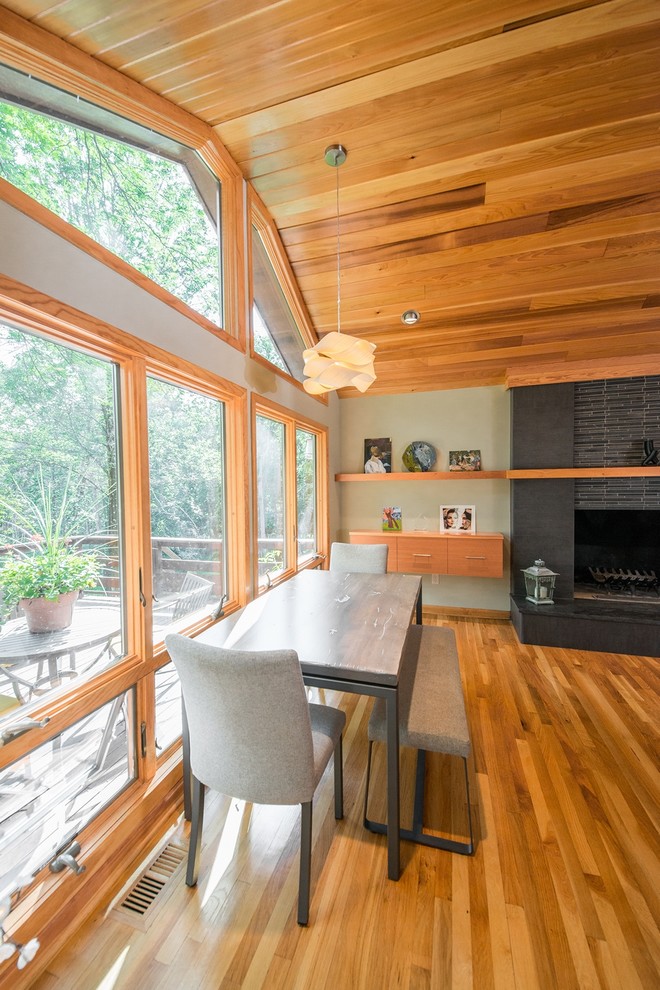 Kleine Moderne Wohnküche mit grauer Wandfarbe, hellem Holzboden, Kamin und Kaminumrandung aus Stein in New York
