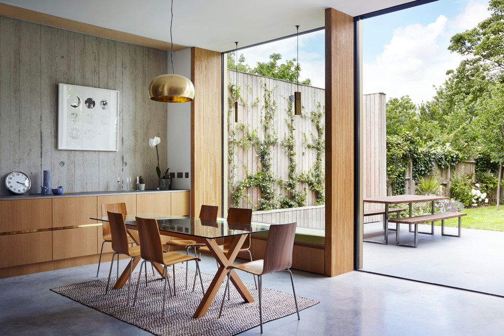 Пример оригинального дизайна: гостиная-столовая среднего размера в современном стиле с серыми стенами и бетонным полом без камина