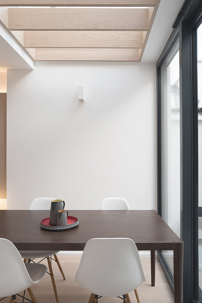Ispirazione per una piccola sala da pranzo aperta verso il soggiorno contemporanea con pareti bianche e parquet chiaro