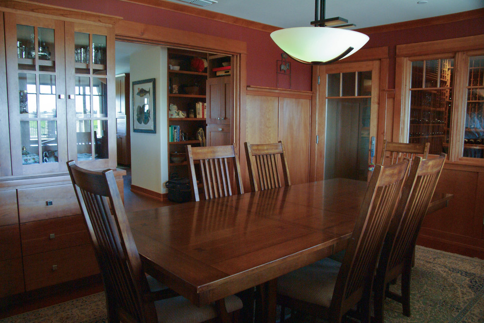 Cette photo montre une salle à manger craftsman fermée et de taille moyenne avec un mur marron, un sol en bois brun et aucune cheminée.