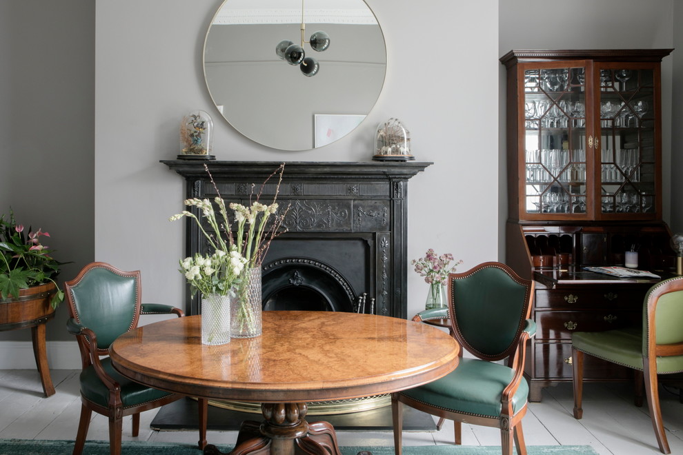 Свежая идея для дизайна: отдельная столовая в классическом стиле с серыми стенами, деревянным полом, стандартным камином и серым полом - отличное фото интерьера