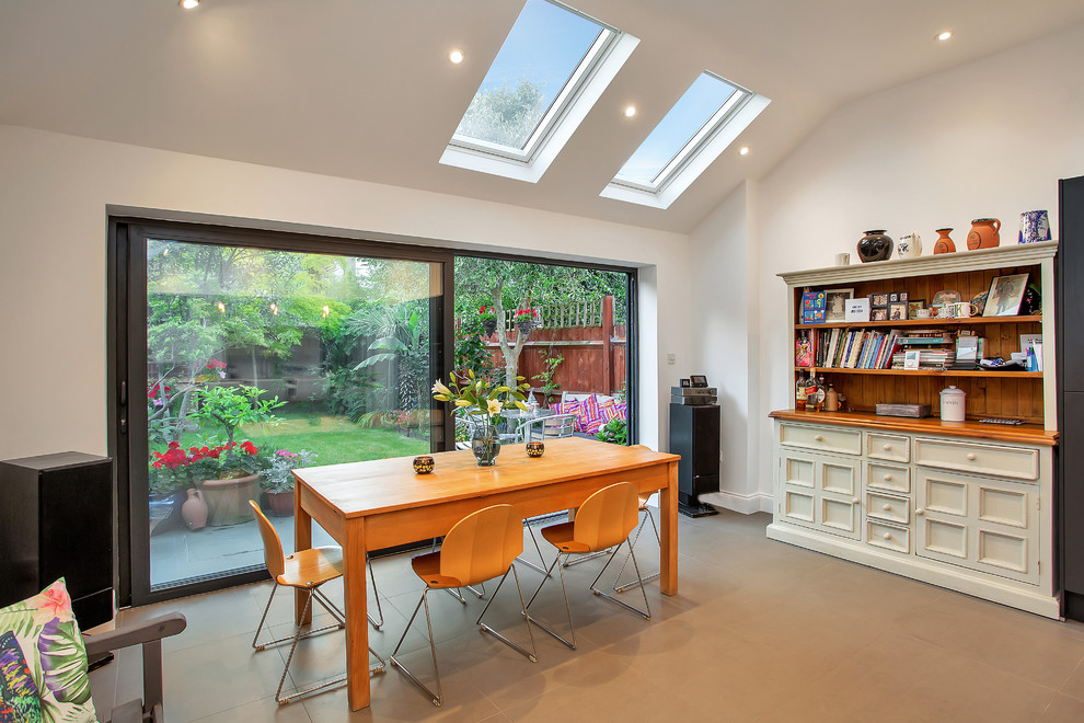 Example of a transitional beige floor kitchen/dining room combo design in London with white walls