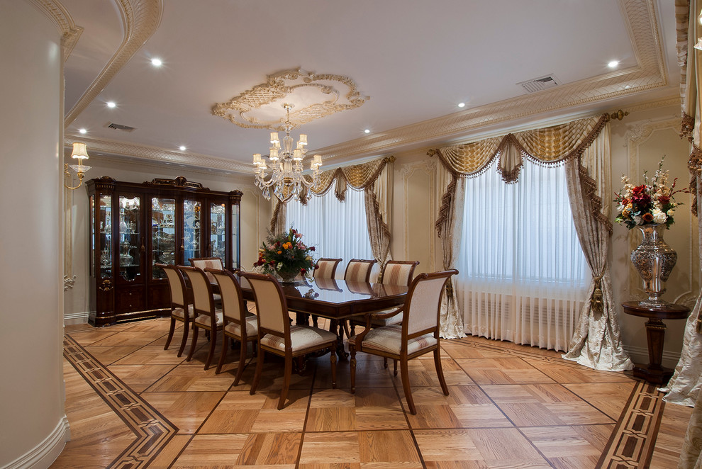 Example of a large classic medium tone wood floor dining room design in New York with beige walls