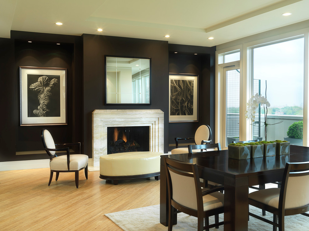 Classic dining room in St Louis with black walls, medium hardwood flooring and a standard fireplace.