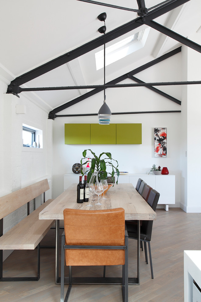 Exemple d'une salle à manger ouverte sur le salon tendance avec un mur blanc, un sol en bois brun et aucune cheminée.