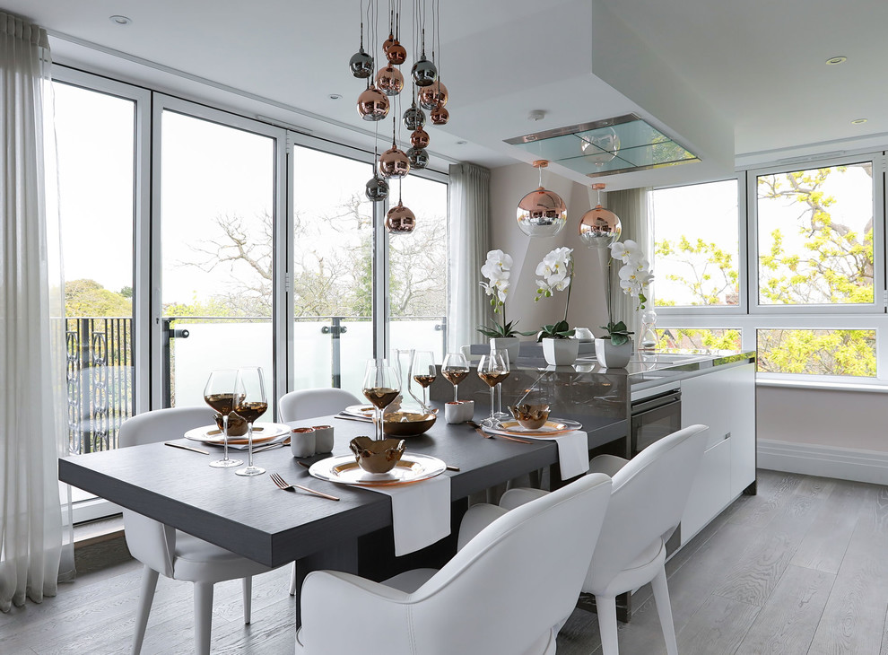 Inspiration pour une salle à manger ouverte sur la cuisine design avec un mur beige, parquet clair et un sol marron.