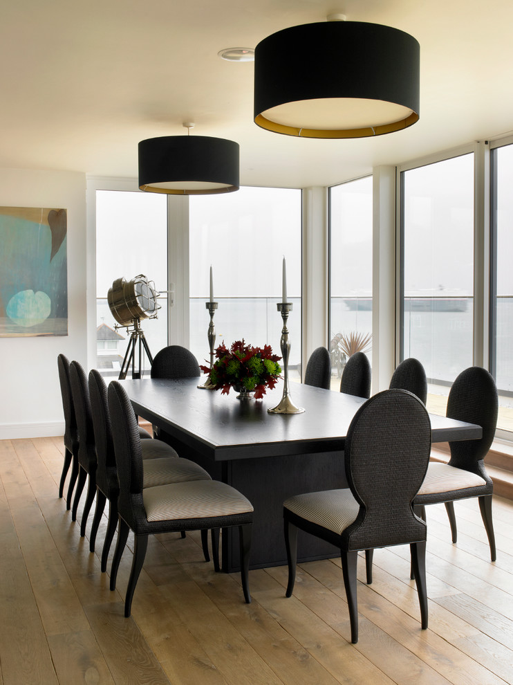 Photo of a contemporary dining room in Wiltshire with medium hardwood flooring and white walls.